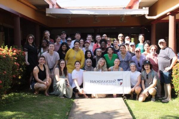Shenandoah health professions and 药店 students and faculty gathered around a Shenandoah banner in Nicaragua in 2024.